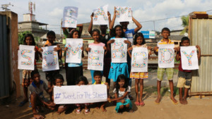 Photo of children working with SERVE, Sri Lanka holding their fingerprint artwork for the I Am Somebody campaign.