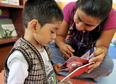 A photo of a mother reading with her son at JUCONI House